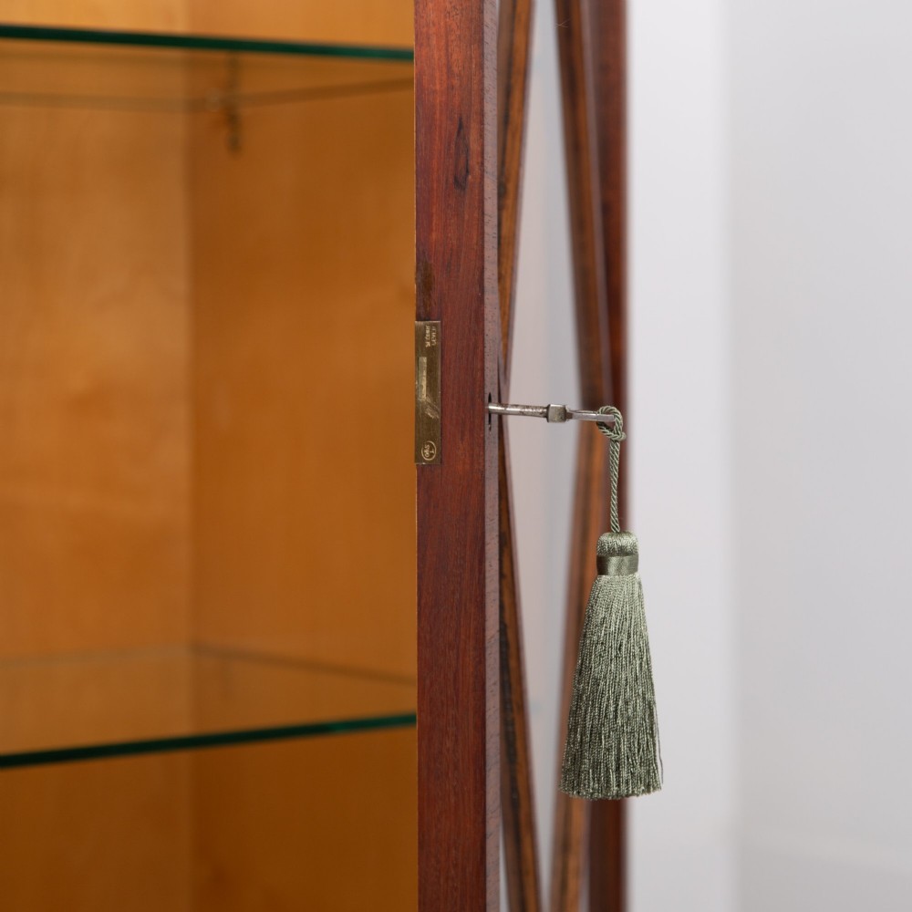 An Art Deco walnut display cabinet featuring a central burr walnut door flanked by two glazed doors with geometric diamond glazing bars. View IV