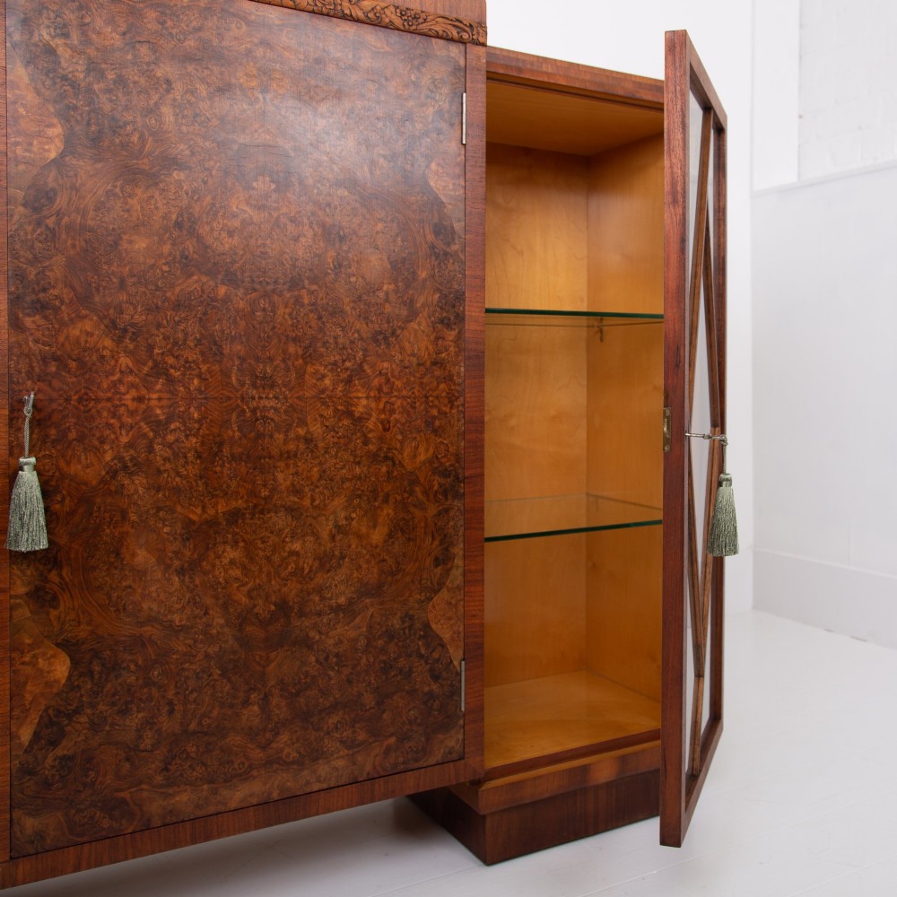 An Art Deco walnut display cabinet featuring a central burr walnut door flanked by two glazed doors with geometric diamond glazing bars. View V