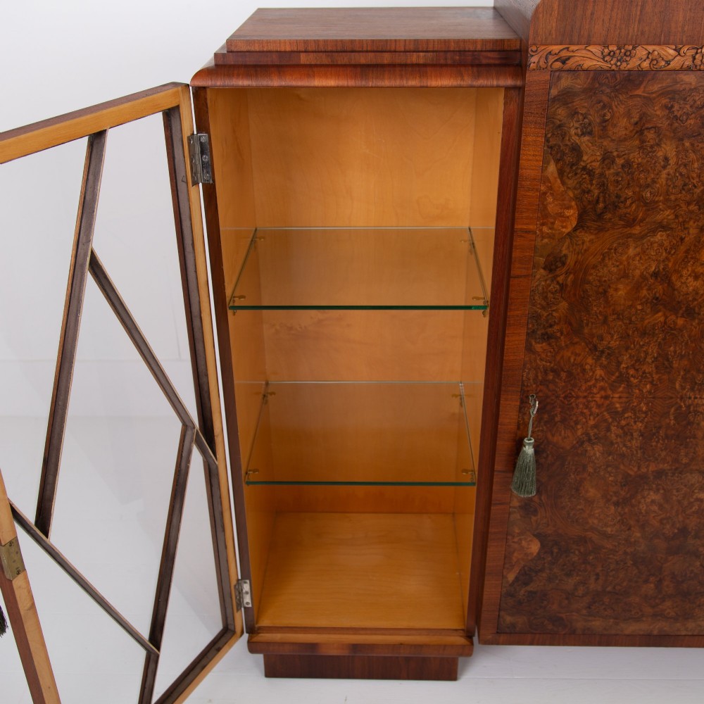 An Art Deco walnut display cabinet featuring a central burr walnut door flanked by two glazed doors with geometric diamond glazing bars. View IX
