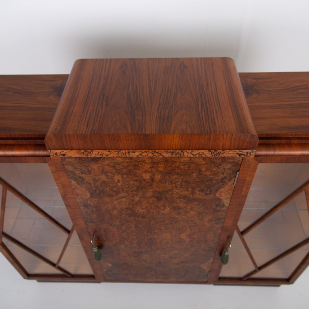 An Art Deco walnut display cabinet featuring a central burr walnut door flanked by two glazed doors with geometric diamond glazing bars. View XIV