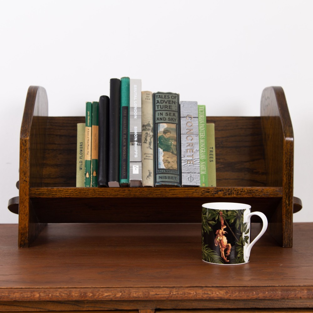 An English Arts and Crafts medium brown oak book trough featuring angled shelf panels and exposed wedge peg joinery. View IV