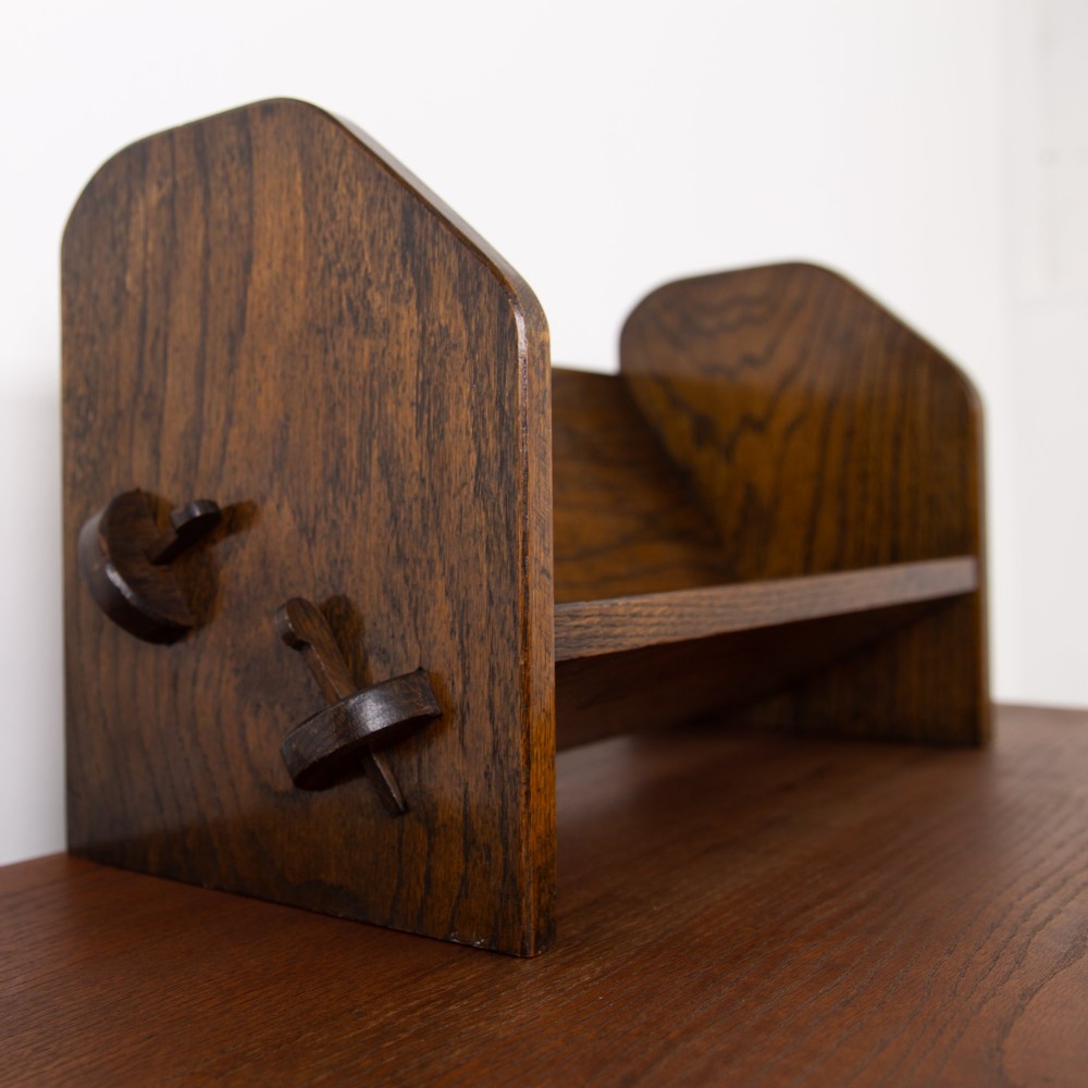 An English Arts and Crafts medium brown oak book trough featuring angled shelf panels and exposed wedge peg joinery. View V