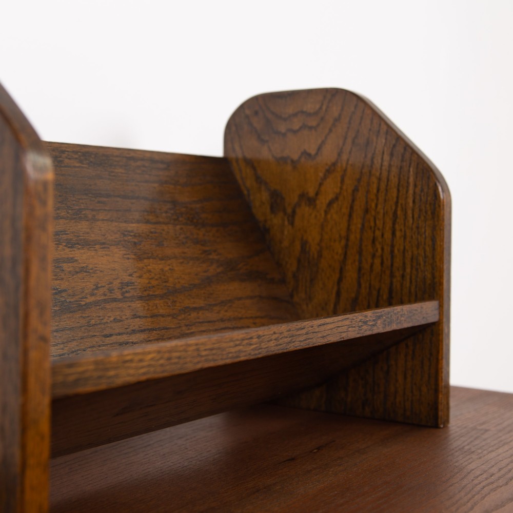 An English Arts and Crafts medium brown oak book trough featuring angled shelf panels and exposed wedge peg joinery. View VI