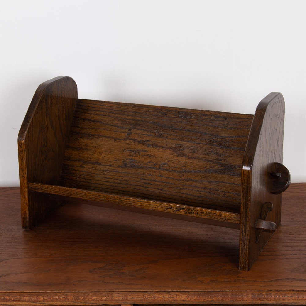 An English Arts and Crafts medium brown oak book trough featuring angled shelf panels and exposed wedge peg joinery. View VII