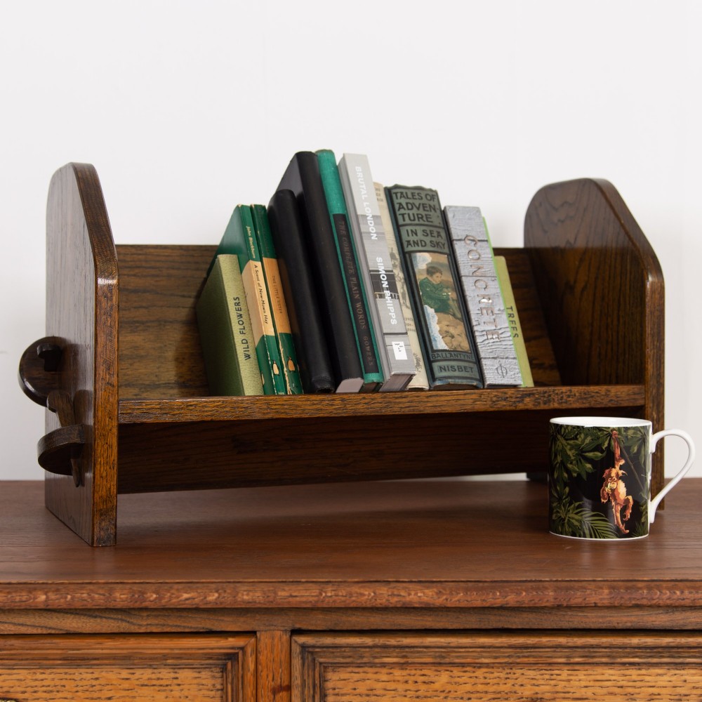 An English Arts and Crafts medium brown oak book trough featuring angled shelf panels and exposed wedge peg joinery. View XI