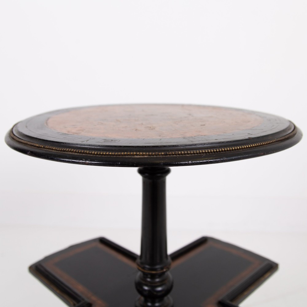 A Victorian ebonised side table featuring a circular top inlaid with amboyna wood, a central turned column, a lower cruciform tier, and a four-point flared base. View III