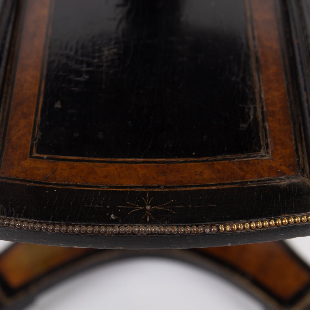 A Victorian ebonised side table featuring a circular top inlaid with amboyna wood, a central turned column, a lower cruciform tier, and a four-point flared base. View V
