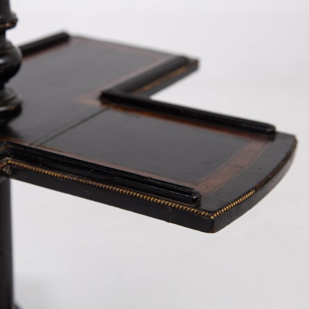 A Victorian ebonised side table featuring a circular top inlaid with amboyna wood, a central turned column, a lower cruciform tier, and a four-point flared base. View XII