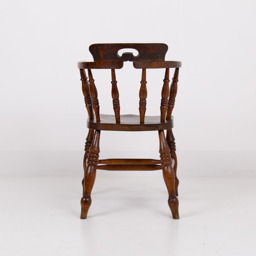 An antique 19th-century wooden smokers bow armchair with turned spindles, a curved horseshoe armrest, and a shaped seat. View VI