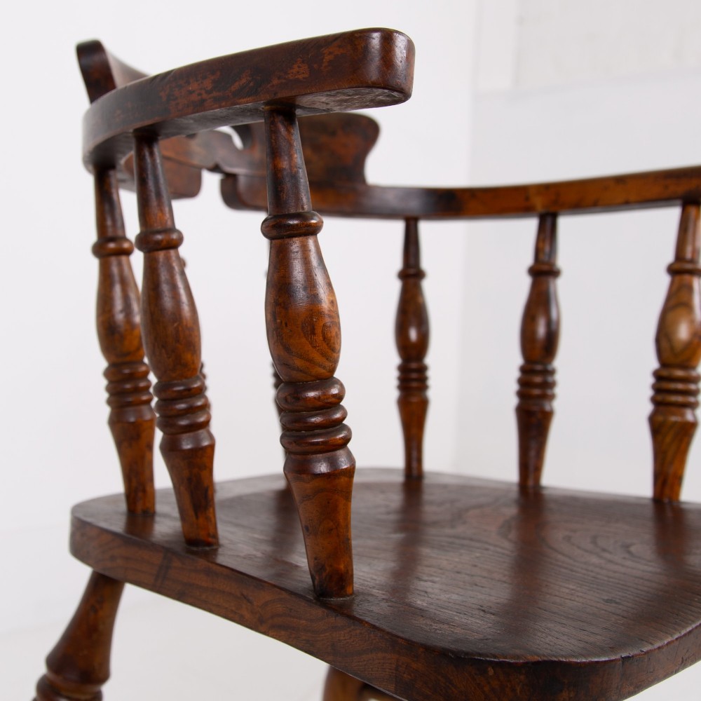 An antique 19th-century wooden smokers bow armchair with turned spindles, a curved horseshoe armrest, and a shaped seat. View VII