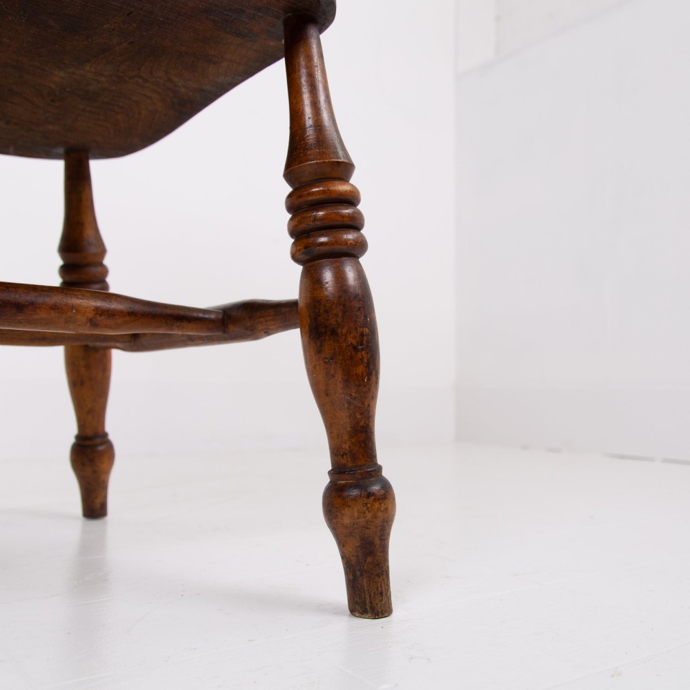 An antique 19th-century wooden smokers bow armchair with turned spindles, a curved horseshoe armrest, and a shaped seat. View XI