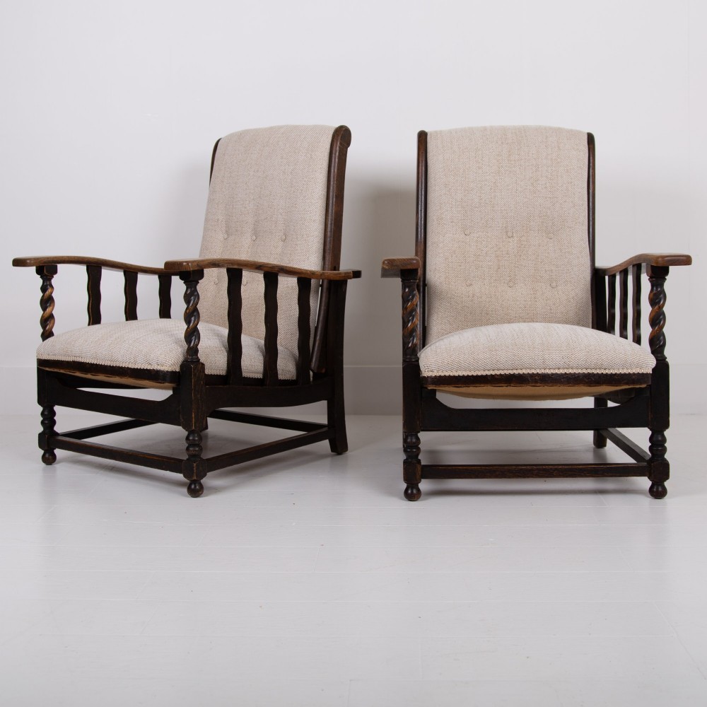 A pair of dark oak reclining armchairs with barley twist front supports, slatted sides, and beige textured upholstery. View II