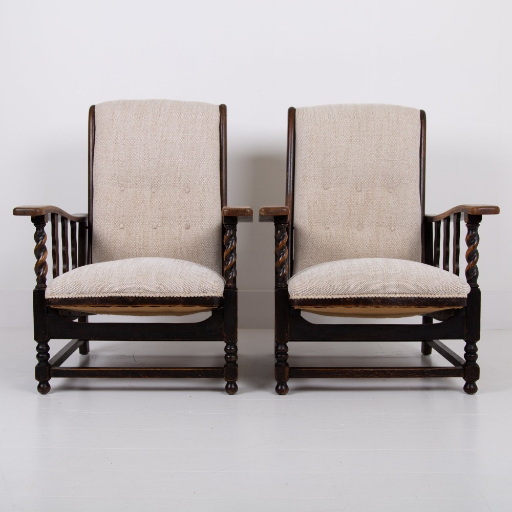A pair of dark oak reclining armchairs with barley twist front supports, slatted sides, and beige textured upholstery. View III