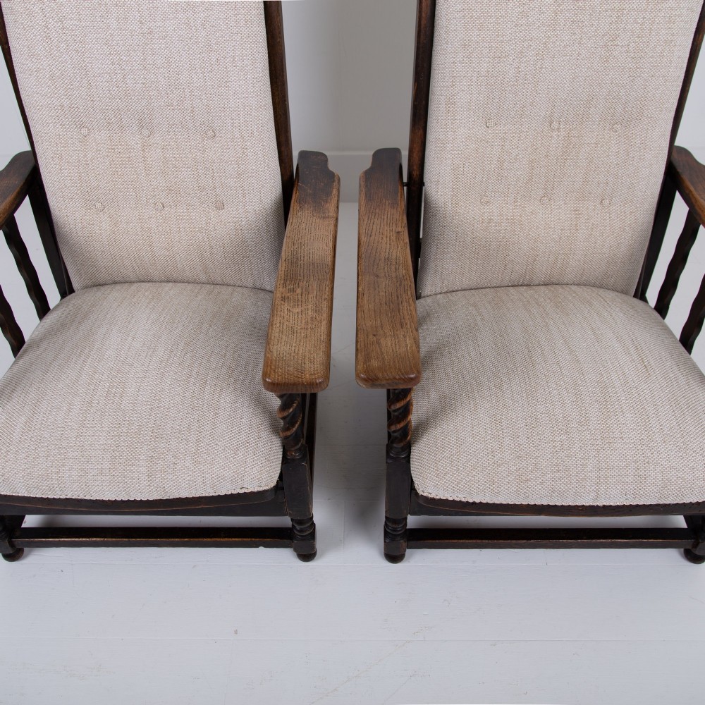 A pair of dark oak reclining armchairs with barley twist front supports, slatted sides, and beige textured upholstery. View IV