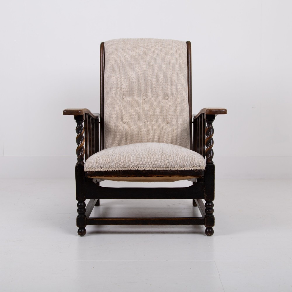 A pair of dark oak reclining armchairs with barley twist front supports, slatted sides, and beige textured upholstery. View VI