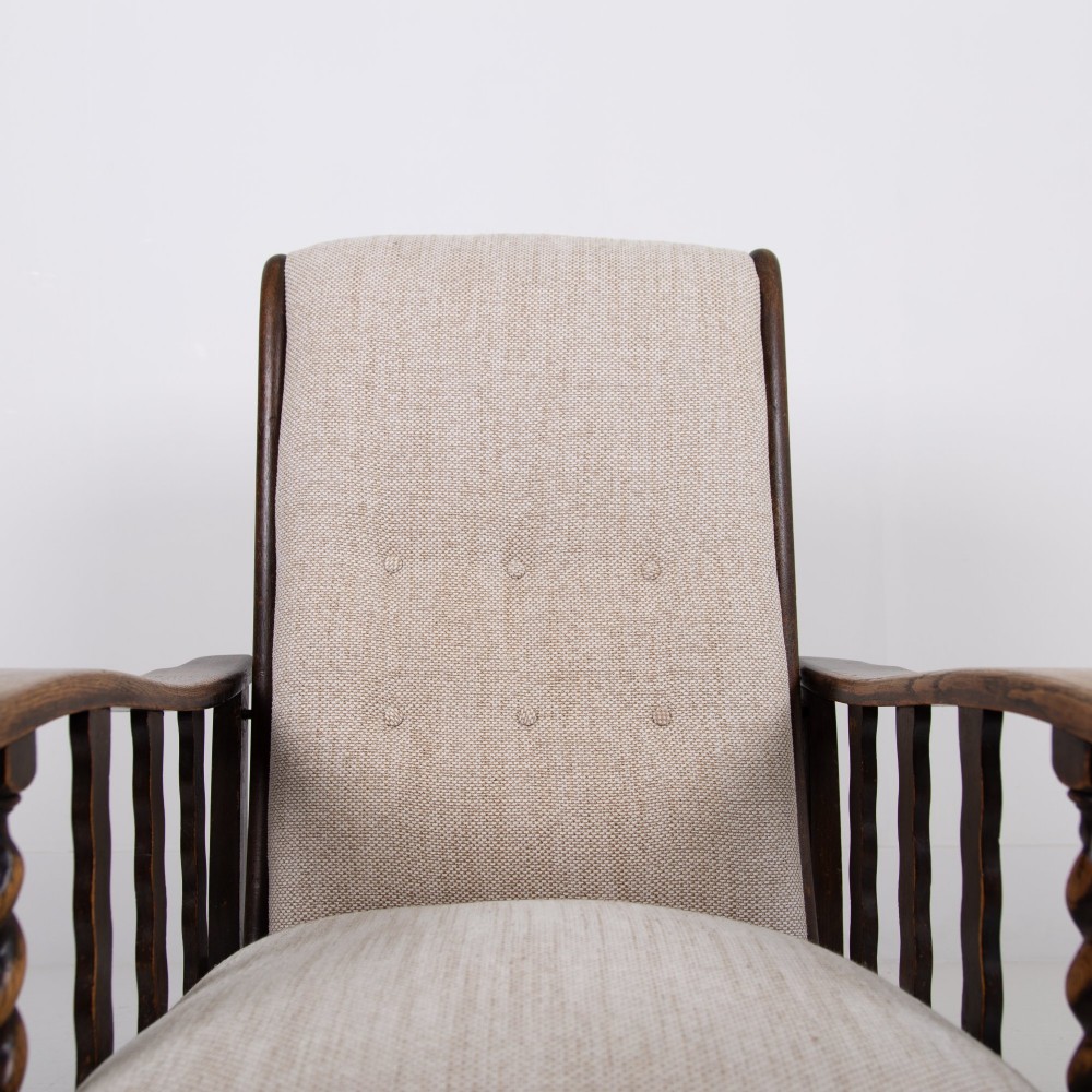 A pair of dark oak reclining armchairs with barley twist front supports, slatted sides, and beige textured upholstery. View XIII