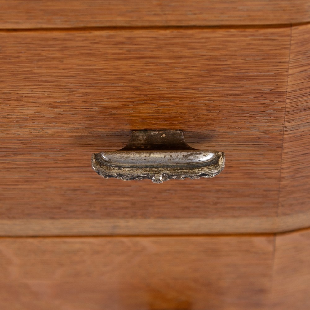 A 1930s Art Deco oak tallboy cabinet featuring a two-door upper cupboard with geometric paneling above two wide drawers, resting on stylized stepped feet. View X
