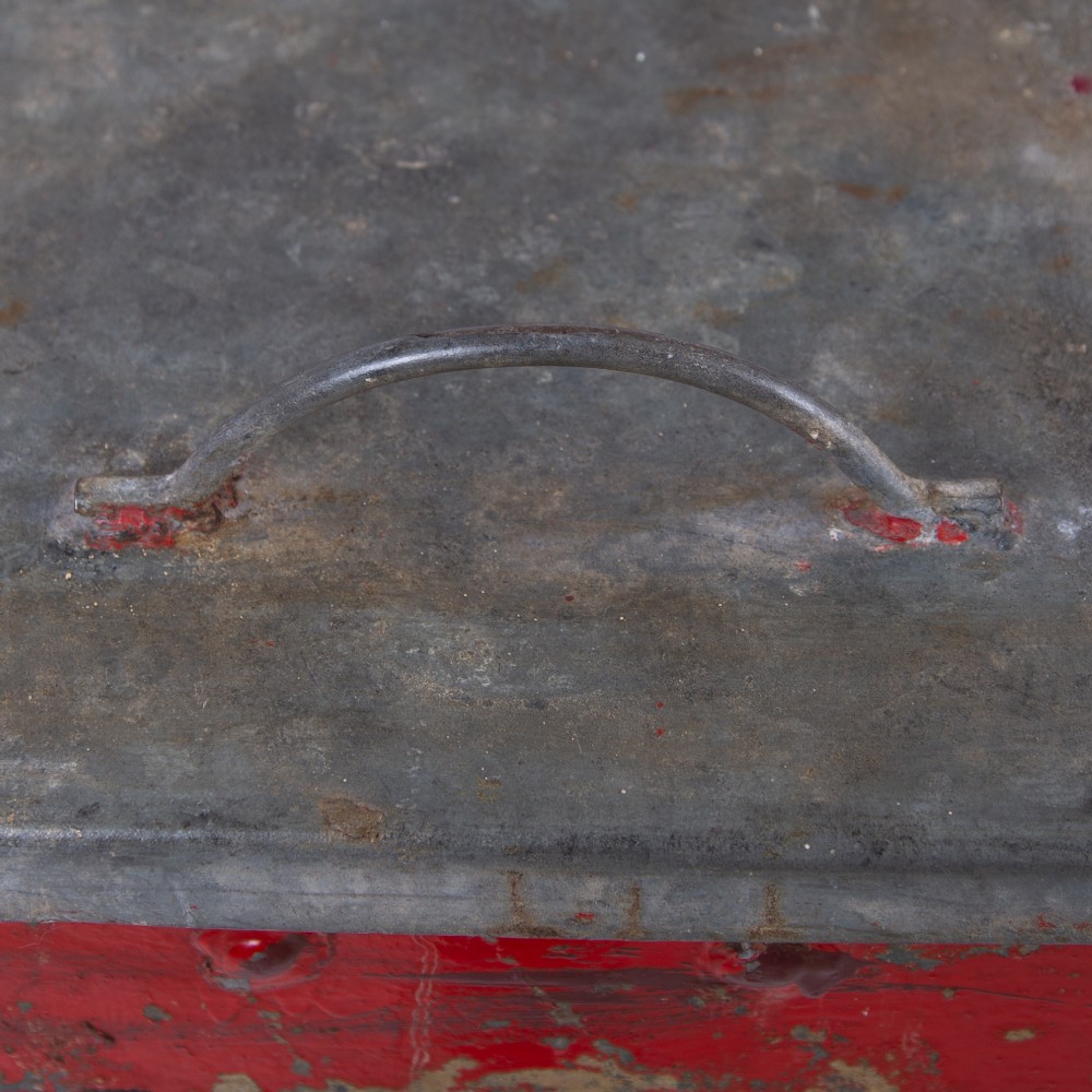 A tall rectangular industrial metal fire bin with distressed red paint, stencilled black text, a top lid, and four small cast iron swivel castors. View VIII