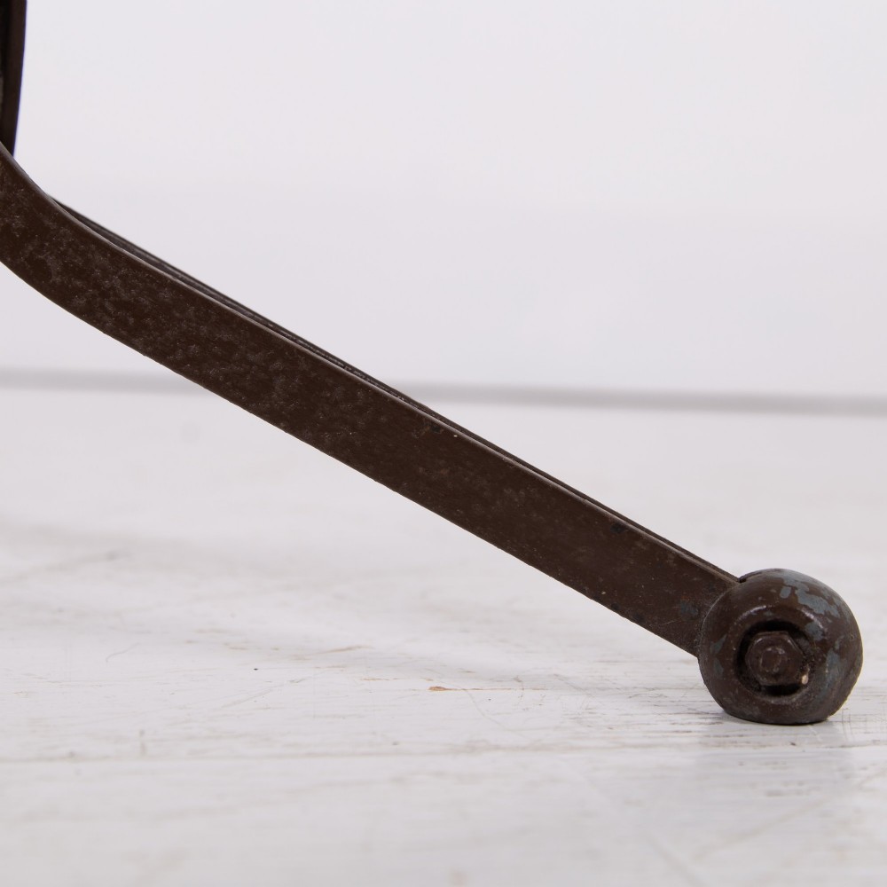 An industrial 1930s workshop stool featuring a circular wooden seat mounted on a dark brown metal tripod base with a threaded height adjustment mechanism. View III