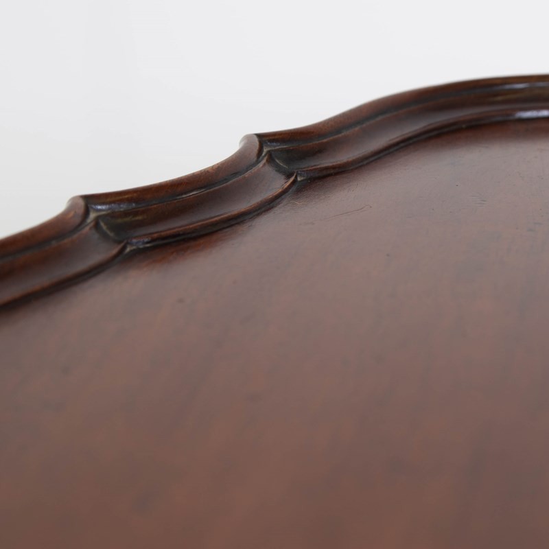 An antique dark mahogany side table featuring a scalloped piecrust top, arched aprons, slender cabriole legs with shell-carved knees, and a central circular lower tier. View V