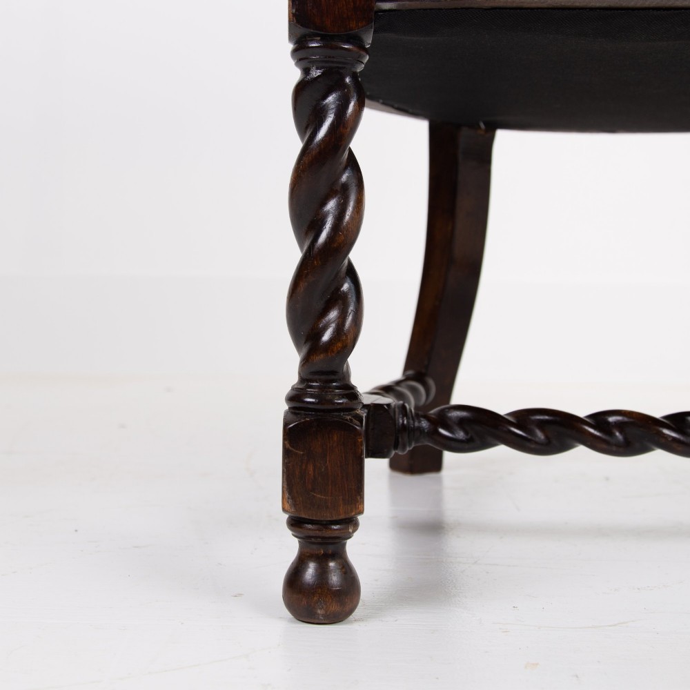 A dark wood Jacobean Revival tub armchair featuring woven cane panelling, carved barley twist legs, and a floral upholstered seat. View VIII