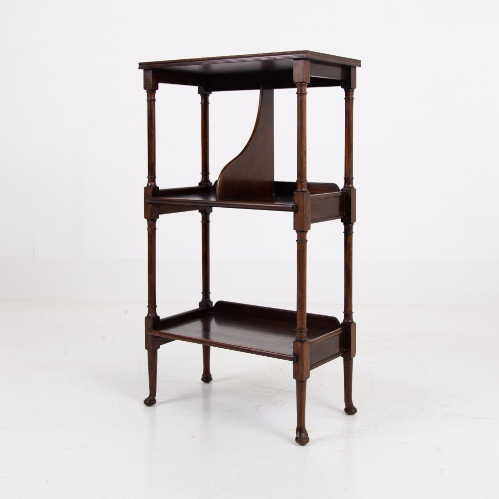 A dark brown mahogany Regency Revival whatnot with three open shelves, slender turned columns, and a vertical divider on the central tier.