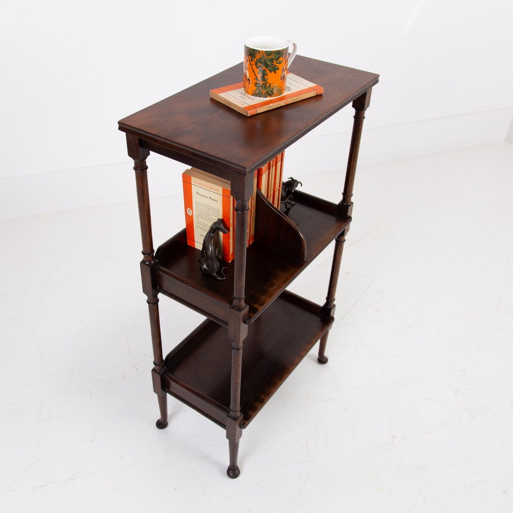 A dark brown mahogany Regency Revival whatnot with three open shelves, slender turned columns, and a vertical divider on the central tier. View II