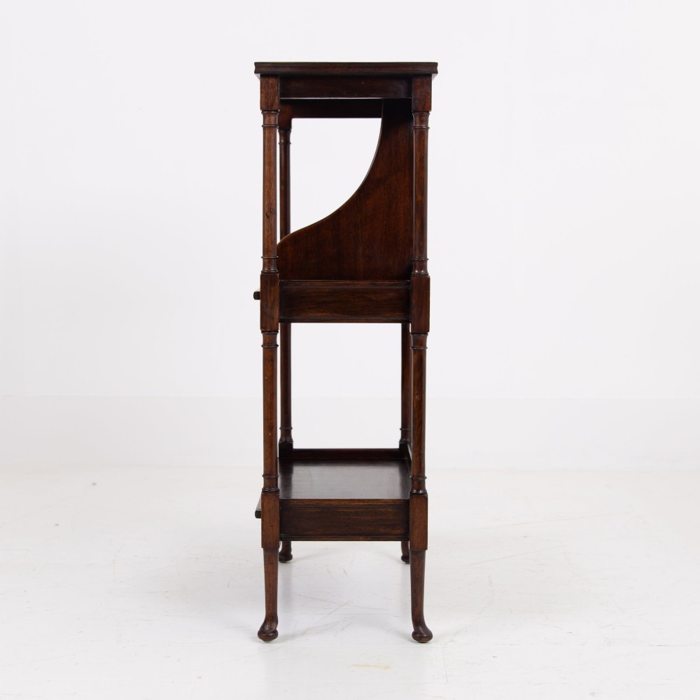 A dark brown mahogany Regency Revival whatnot with three open shelves, slender turned columns, and a vertical divider on the central tier. View VII