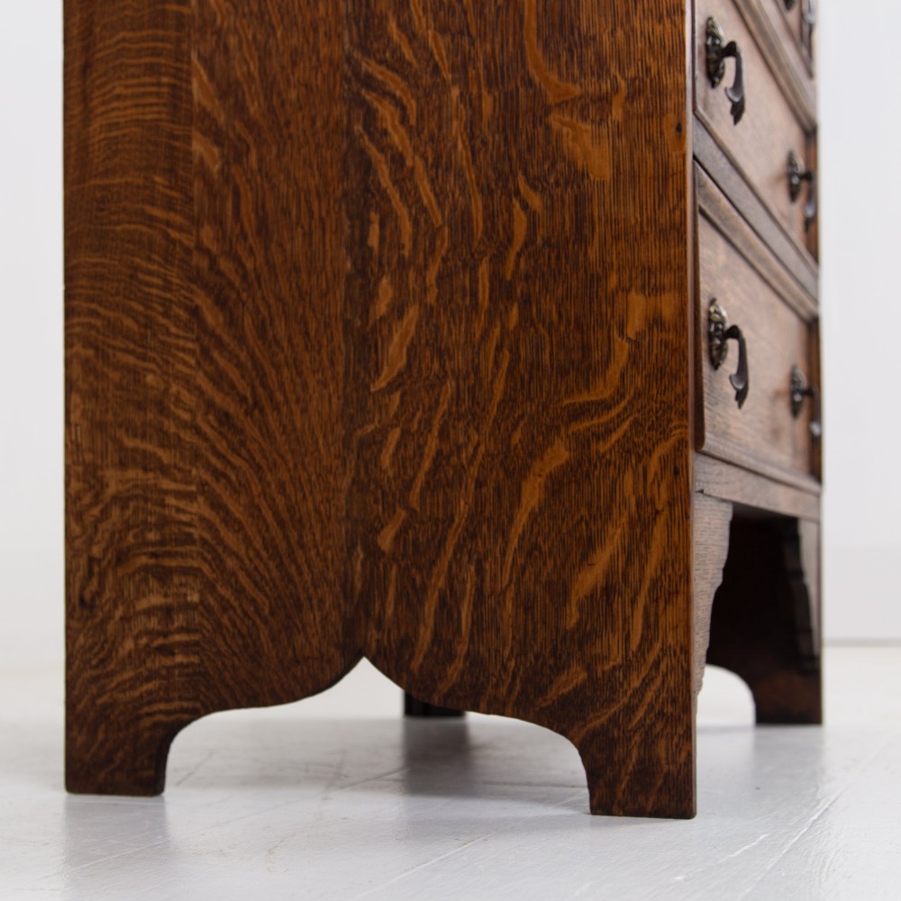A small early 20th-century oak bureau bookcase featuring a leaded glass upper cabinet, a slant-front writing slope, and three lower drawers with brass drop handles. View IX