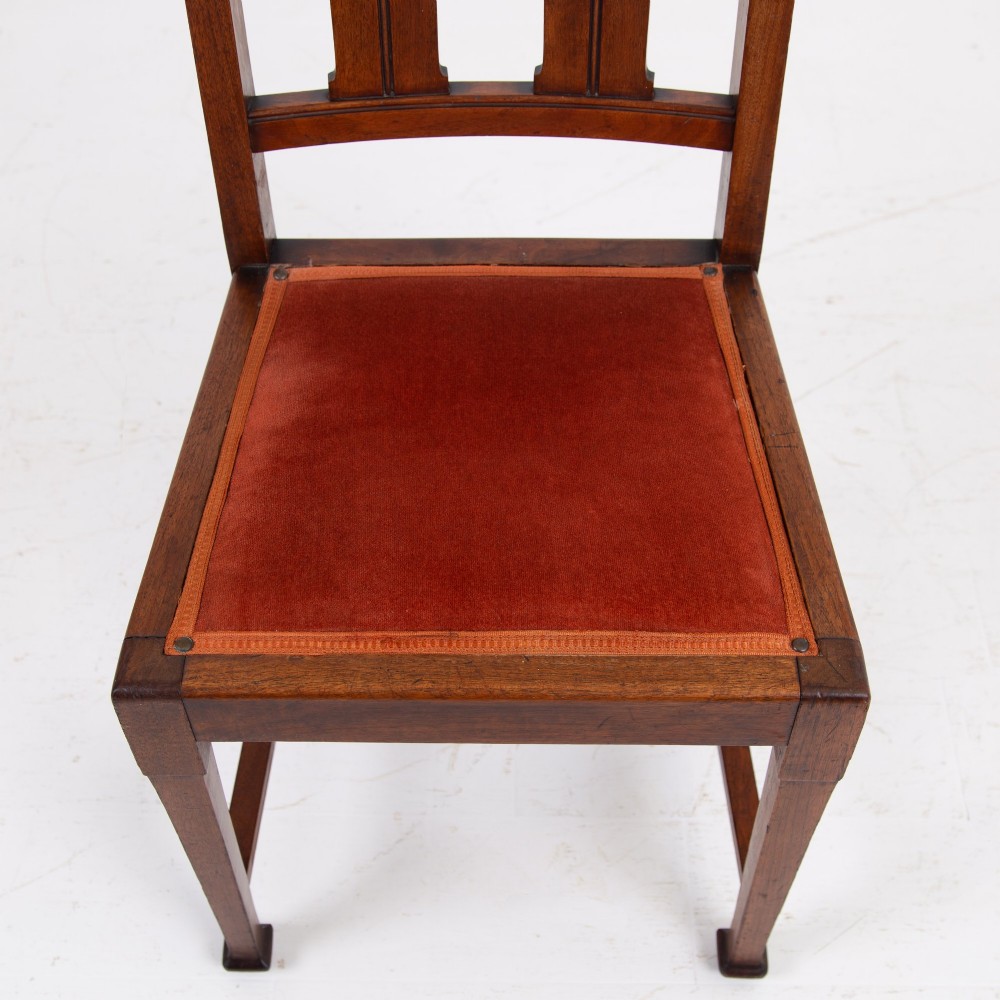 A set of six Scottish Arts and Crafts oak dining chairs featuring high slatted backs with carved roundel details and red velvet seat pads. View IX