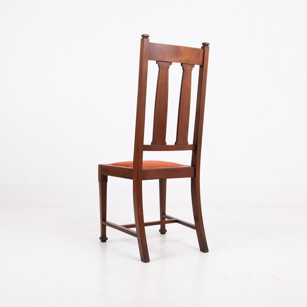 A set of six Scottish Arts and Crafts oak dining chairs featuring high slatted backs with carved roundel details and red velvet seat pads. View XII