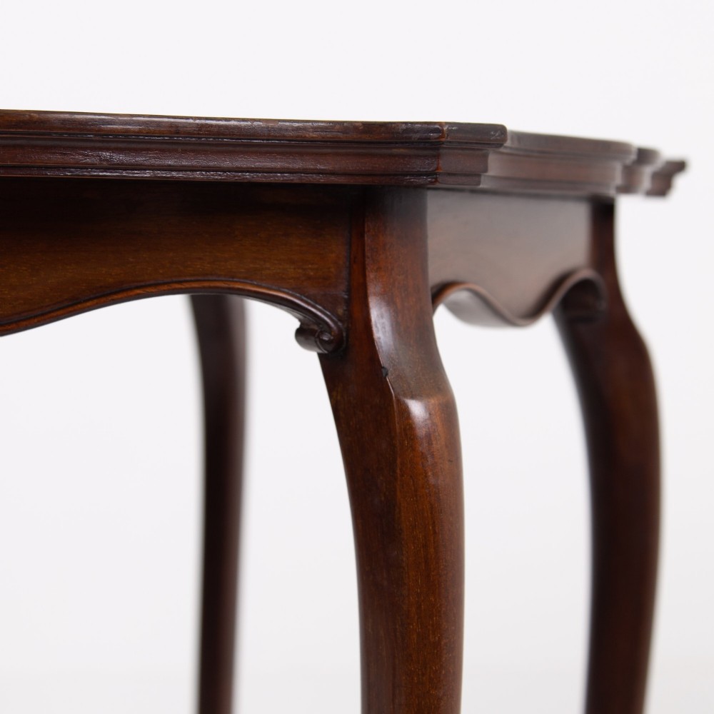 An Edwardian mahogany occasional side table featuring a scalloped rim top, slender cabriole legs, and a matching lower undertier shelf. View V