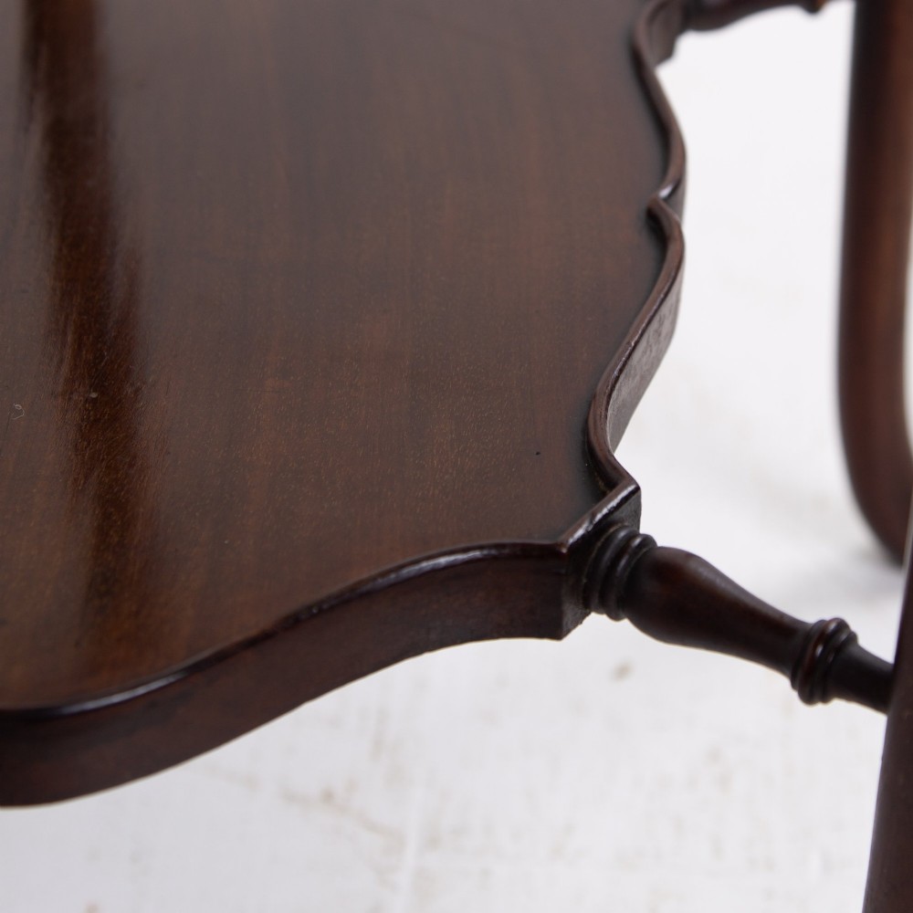 An Edwardian mahogany occasional side table featuring a scalloped rim top, slender cabriole legs, and a matching lower undertier shelf. View VI