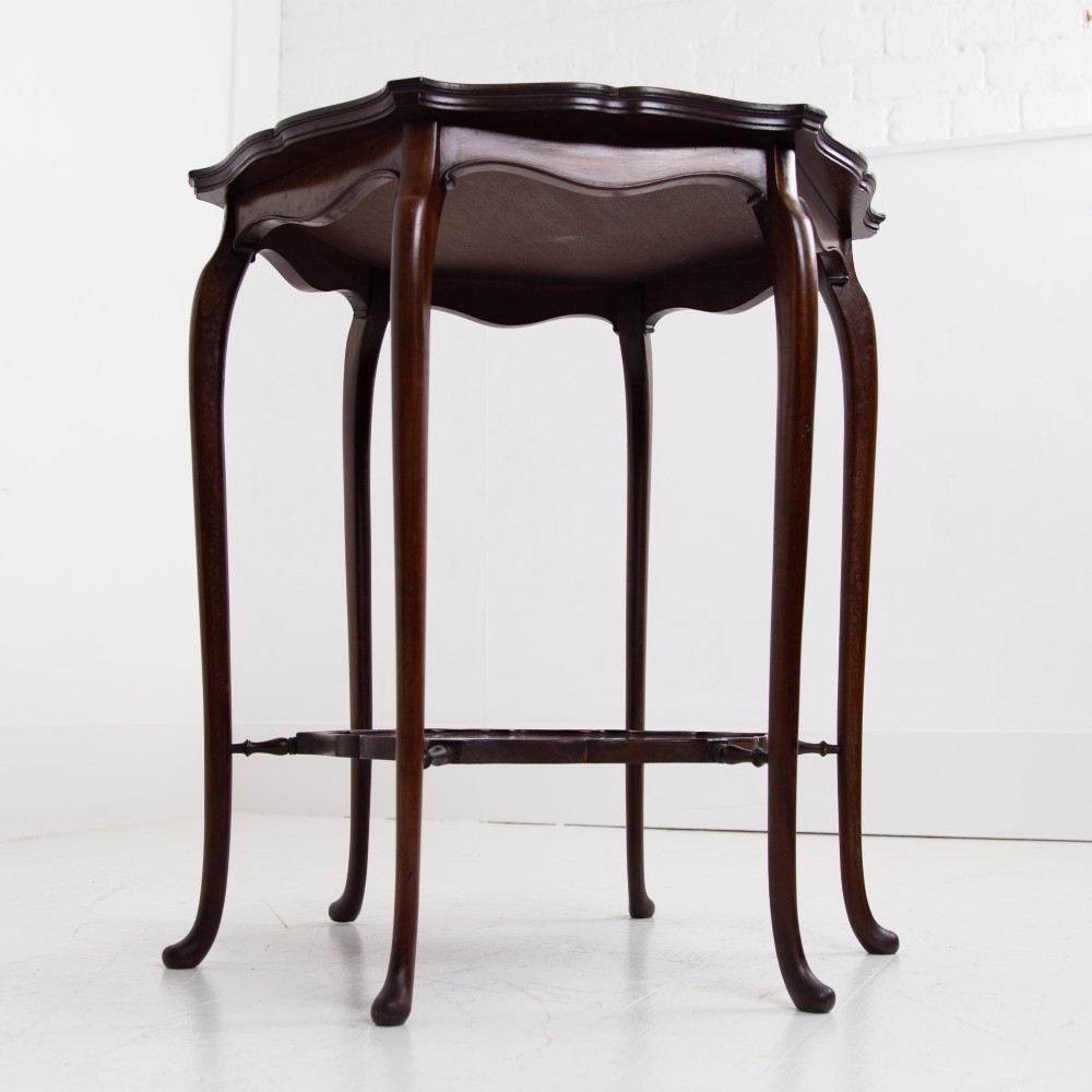 An Edwardian mahogany occasional side table featuring a scalloped rim top, slender cabriole legs, and a matching lower undertier shelf. View VIII