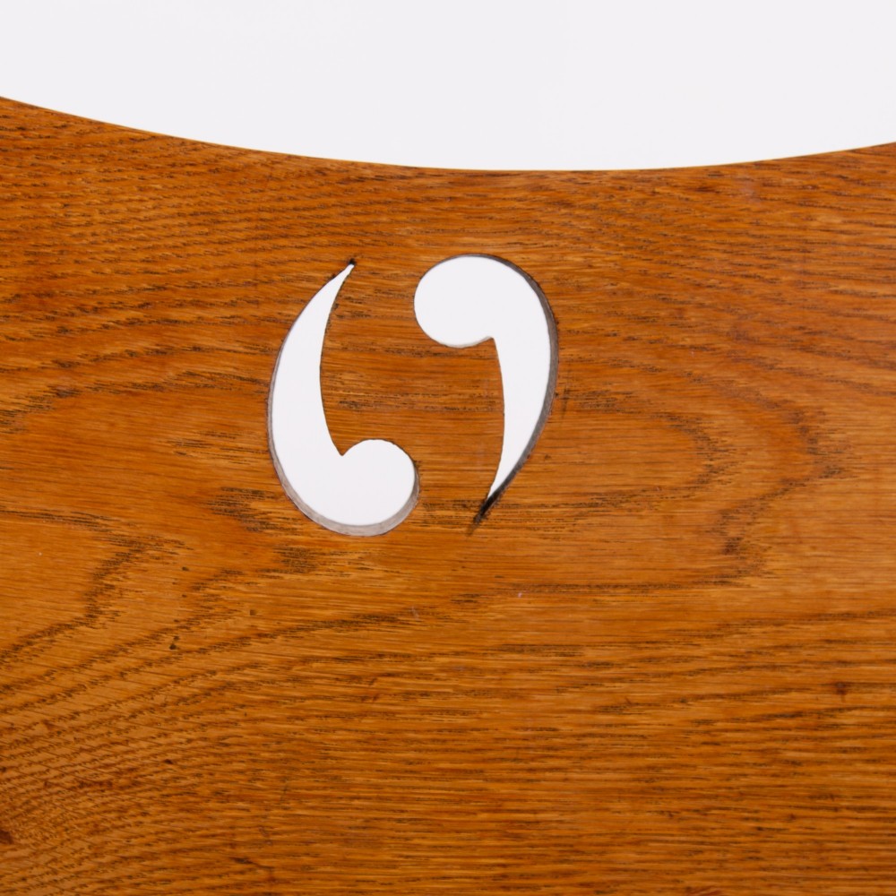 An Arts and Crafts solid oak box settle featuring heart cut-out side panels, an arched backrest, and figural wood inlay on the front apron. View IX