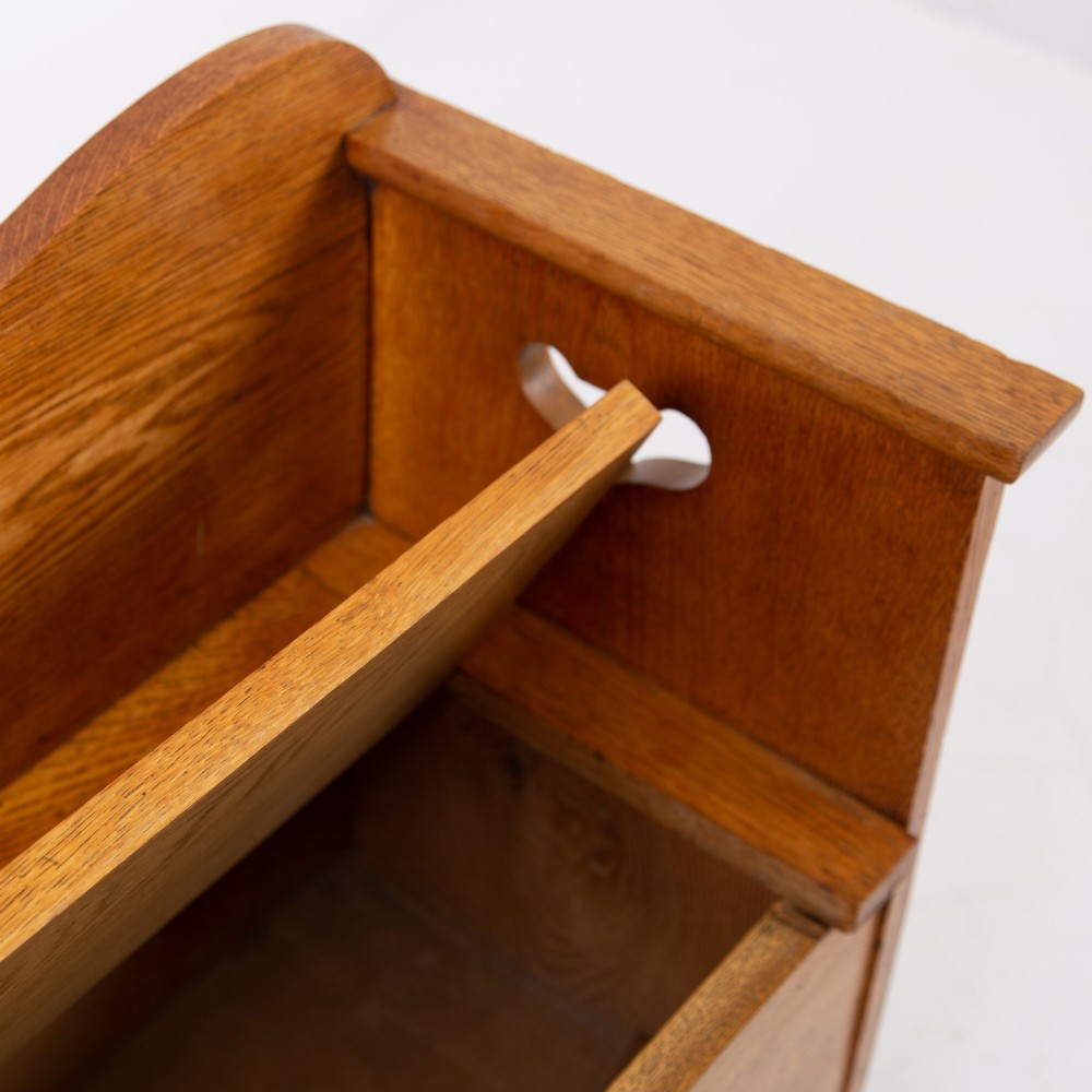 An Arts and Crafts solid oak box settle featuring heart cut-out side panels, an arched backrest, and figural wood inlay on the front apron. View XII
