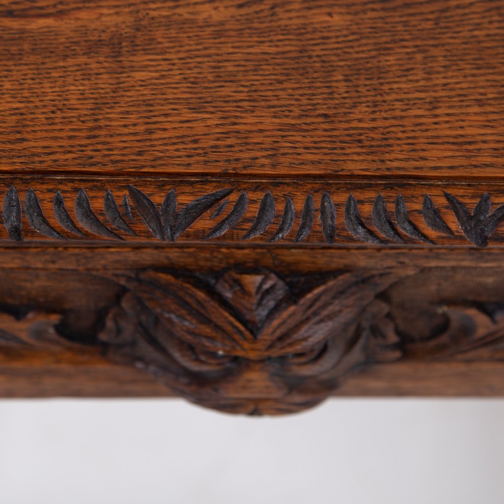 A dark oak Victorian side table featuring a single drawer carved with a Green Man mask motif, bobbin-turned legs, and a lower rectangular stretcher. View XI