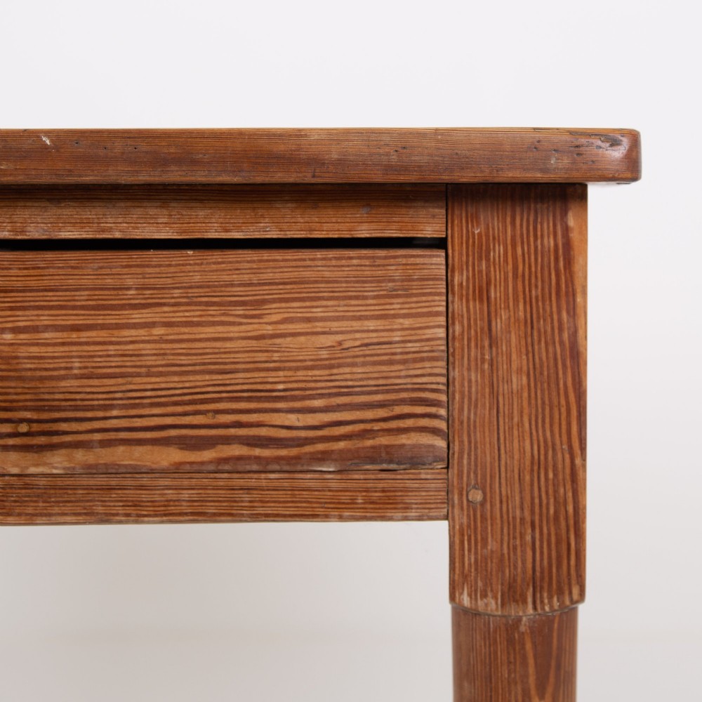 An early 20th-century pitch pine writing desk with two front drawers, wooden turned knobs, and four turned legs. View III