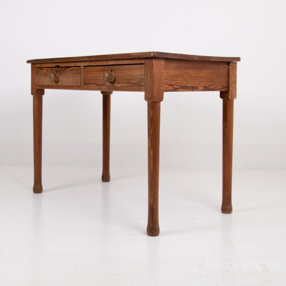 An early 20th-century pitch pine writing desk with two front drawers, wooden turned knobs, and four turned legs. View VII