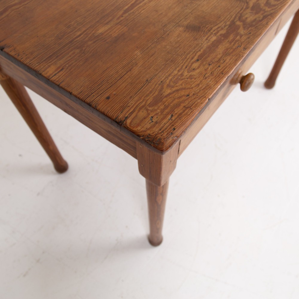 An early 20th-century pitch pine writing desk with two front drawers, wooden turned knobs, and four turned legs. View VIII