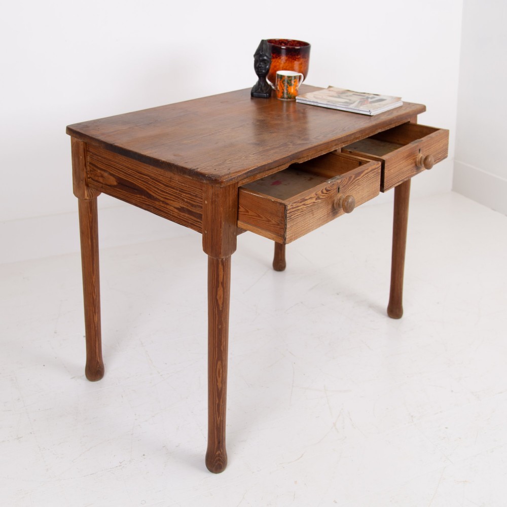An early 20th-century pitch pine writing desk with two front drawers, wooden turned knobs, and four turned legs. View XI