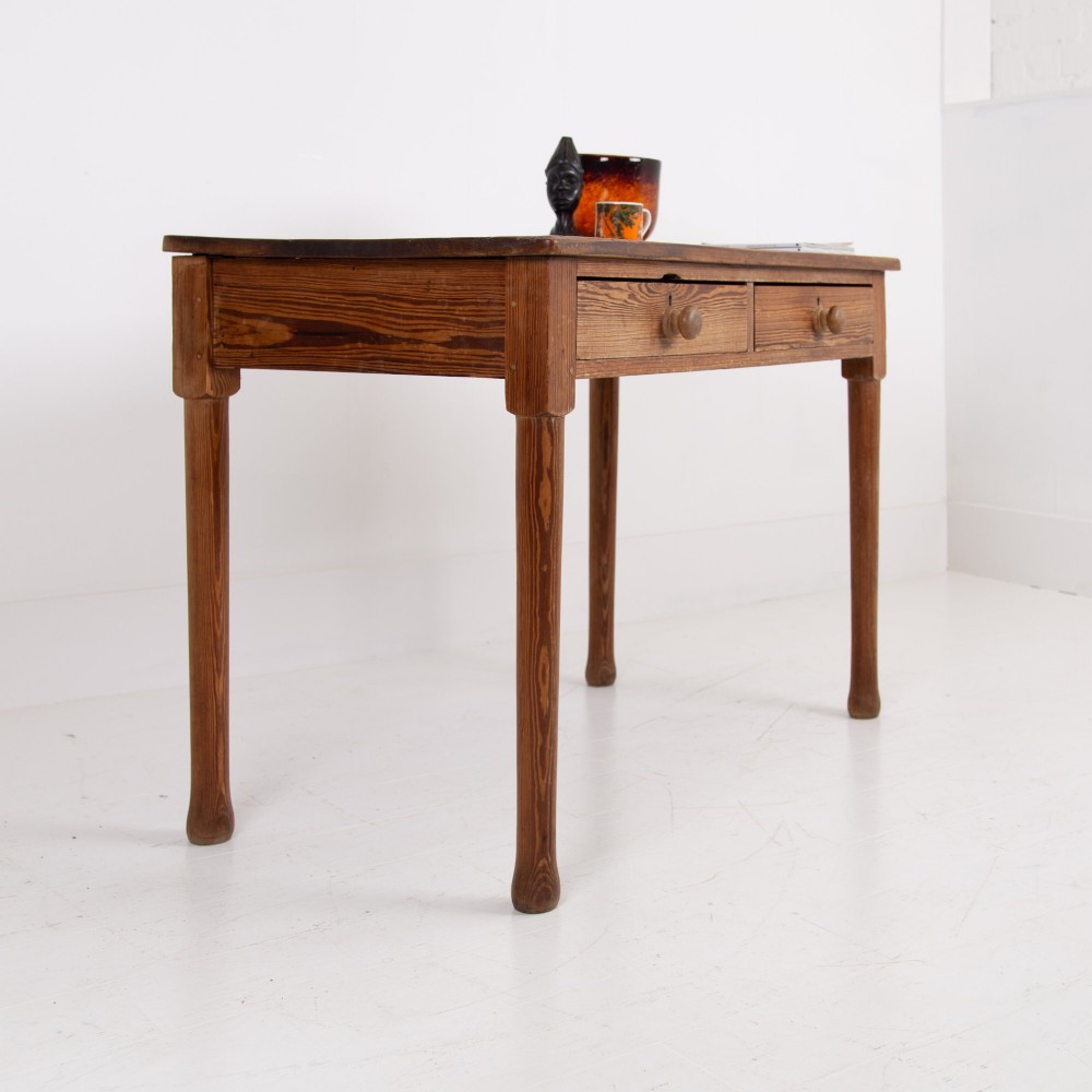 An early 20th-century pitch pine writing desk with two front drawers, wooden turned knobs, and four turned legs. View XII