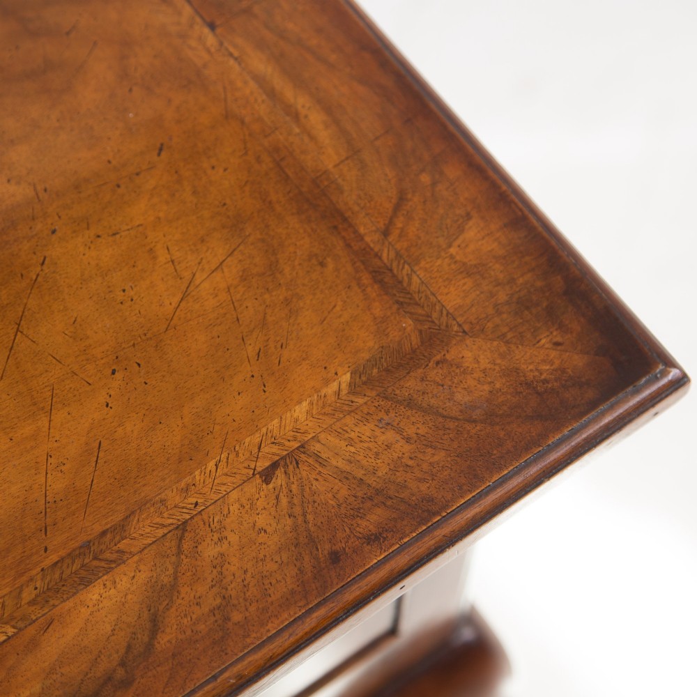 An antique warm brown walnut lowboy table featuring three drawers with brass handles, a shaped apron, and four cabriole legs ending in pad feet. View XI