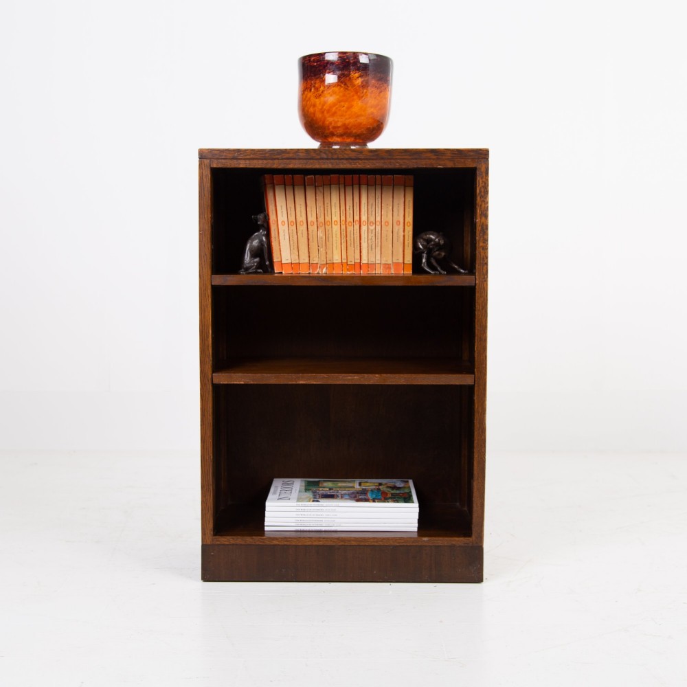 A 1930s dark oak open bookcase featuring two adjustable shelves, a leather-inset top surface, and a solid plinth base. View III