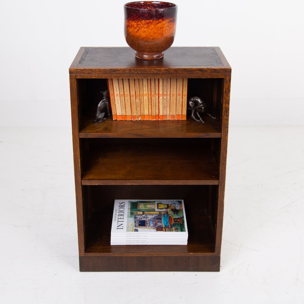 A 1930s dark oak open bookcase featuring two adjustable shelves, a leather-inset top surface, and a solid plinth base. View XI
