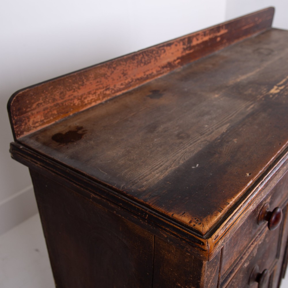 A 19th-century dark brown painted wooden kitchen dresser with seven drawers, a central cupboard, wooden knobs, and turned feet. View XI