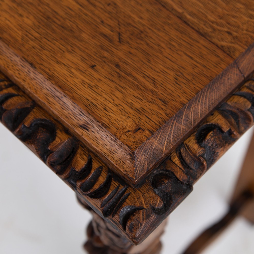 An ornate carved oak console table with a decorative mask crest upstand, an intricate interlace apron design, and carved turned legs. View XIII
