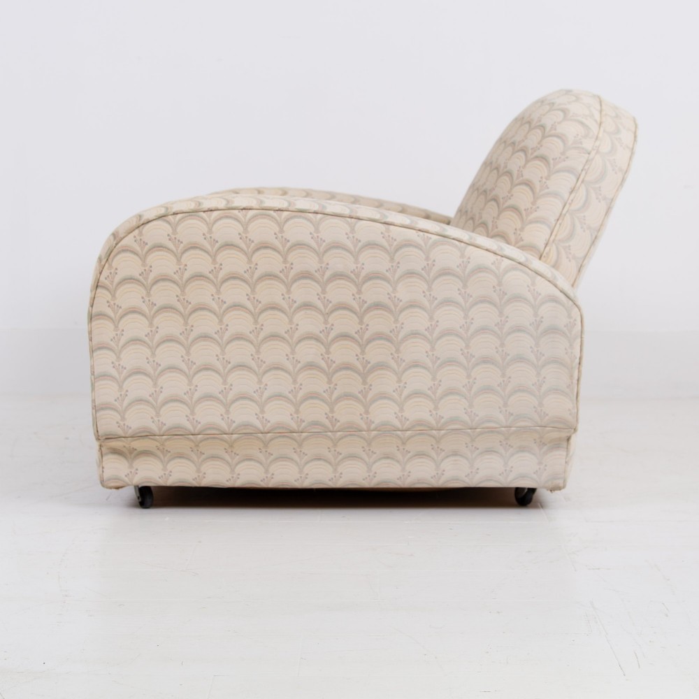 A pair of 1930s Art Deco upholstered armchairs featuring rounded arms, a scalloped fabric pattern, and small integrated casters. View III