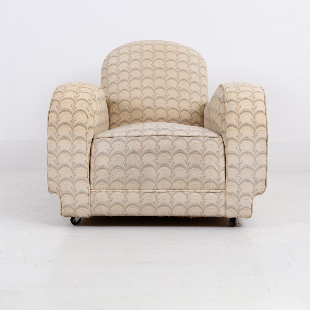 A pair of 1930s Art Deco upholstered armchairs featuring rounded arms, a scalloped fabric pattern, and small integrated casters. View IV