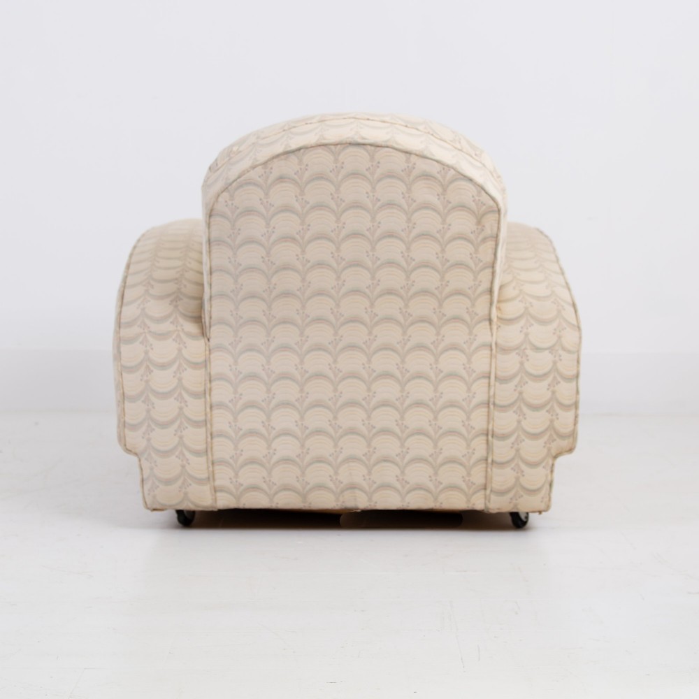 A pair of 1930s Art Deco upholstered armchairs featuring rounded arms, a scalloped fabric pattern, and small integrated casters. View VII